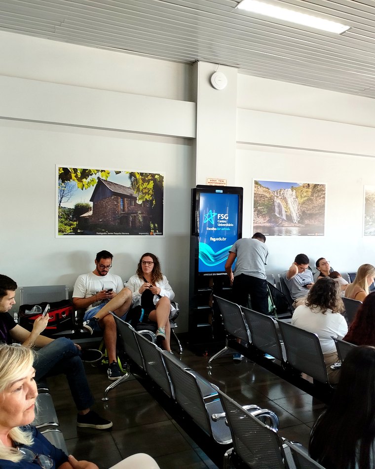 Totem smart.Mooh com tela vertical e estações de recarga de celular instalado em um estabelecimento